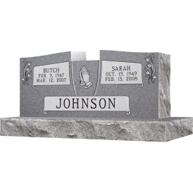 Gray double headstone with praying hands in middle and last name Johnson